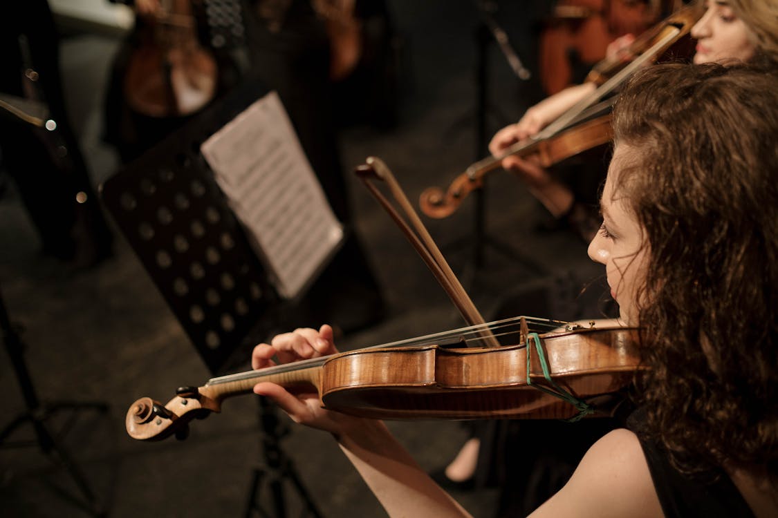 A skilled female violinist playing in an orchestra