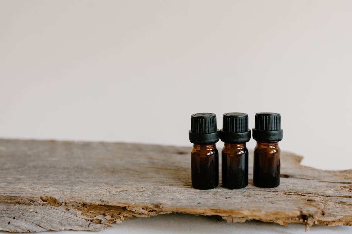 Small glass bottles of essential oils arranged on a wooden surface