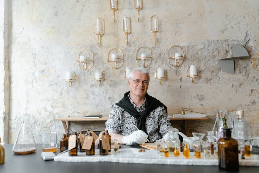 Senior perfumer blending fragrances among bottles