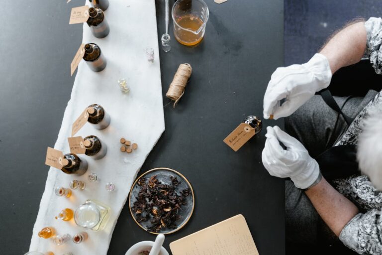 Overhead view of a perfume-making workshop with glass bottles and natural ingredients