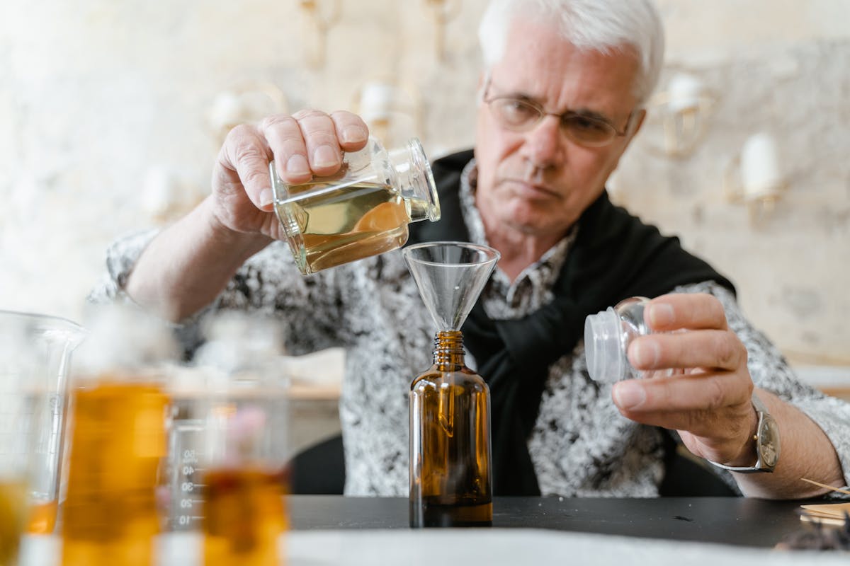 Man carefully blending essential oils for custom fragrance in indoor workshop