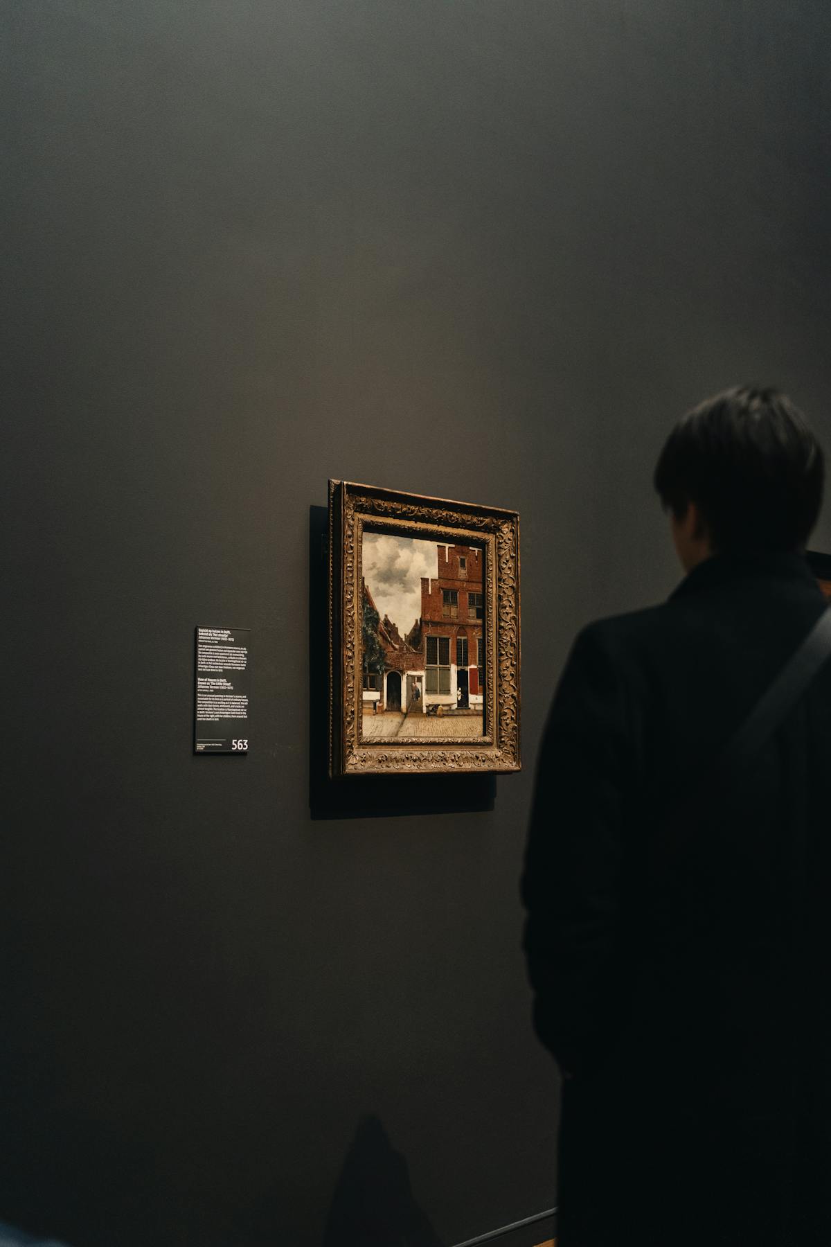 A visitor admiring a classic painting at the Rijksmuseum