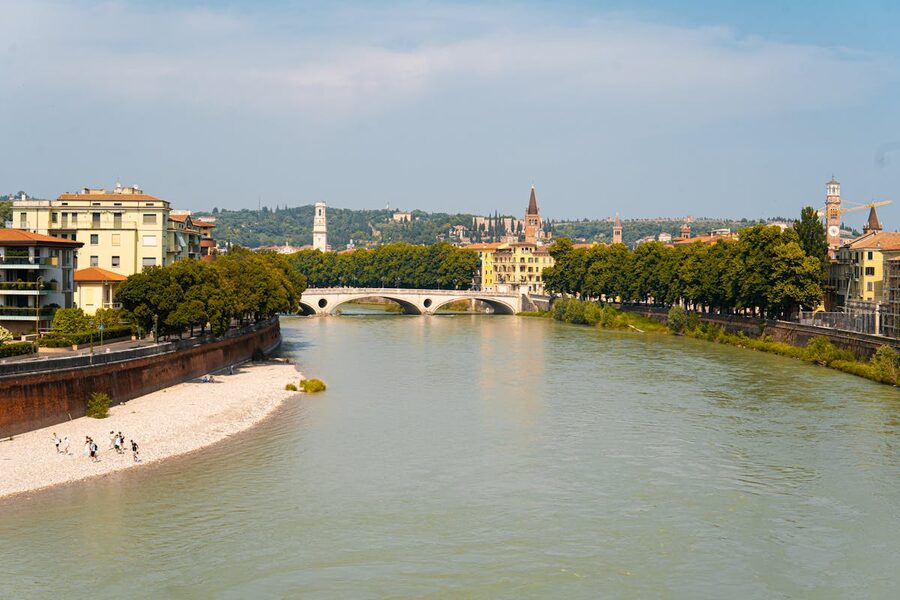 The Adige River winding through Verona with historic buildings along the banks