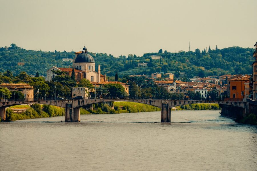 View of a stone bridge and cathedral along the Adige River in Verona
