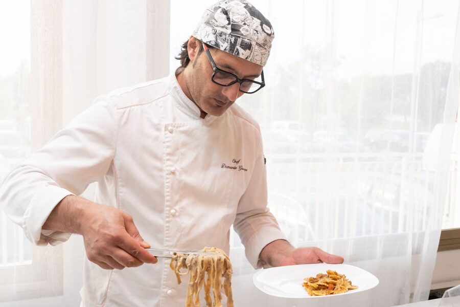Chef plating fresh pasta in a bright kitchen