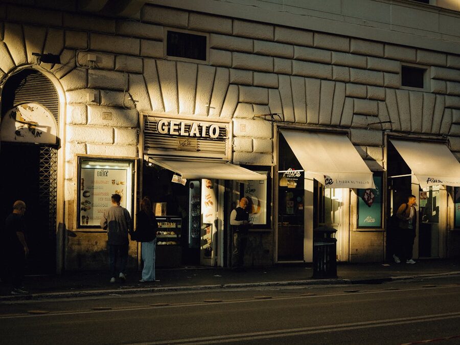 Street view of a gelato shop in Rome with people enjoying gelato outside