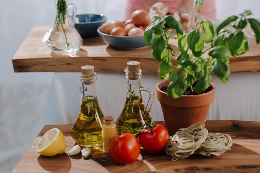 Fresh Italian cooking ingredients including olive oil tomatoes and basil on a table