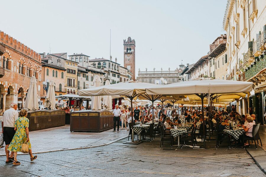 Tourists dining at outdoor restaurants in Piazza delle Erbe market square Verona