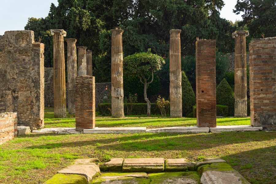 Historic Roman columns with garden backdrop in Pompeii archaeological site