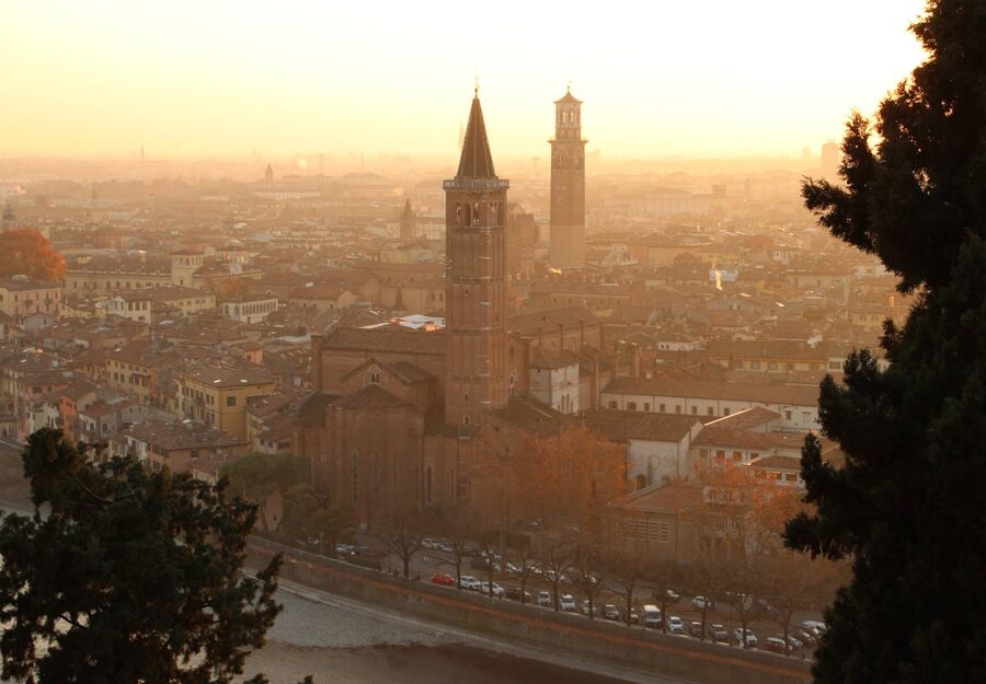 Aerial view of Verona skyline at sunset with towers and historic rooftops