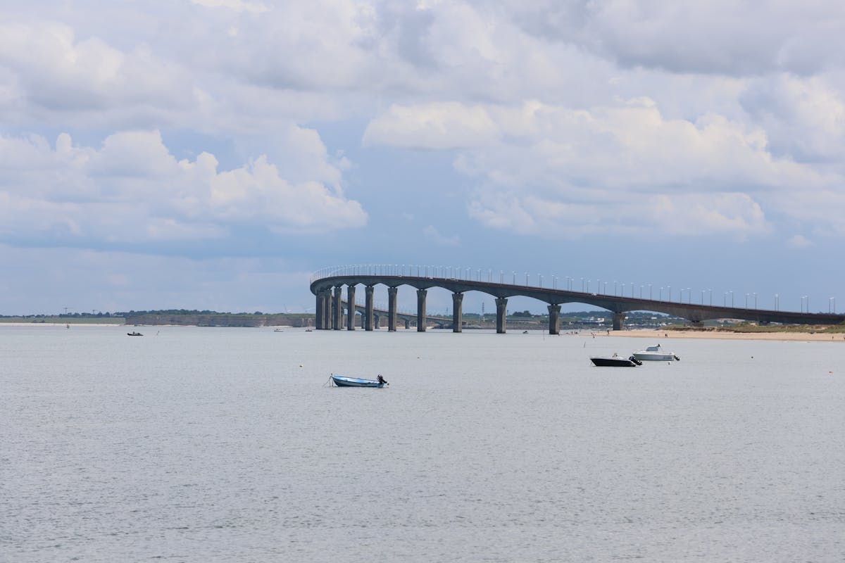 The Ile de Re bridge stretching over calm sea with scattered clouds