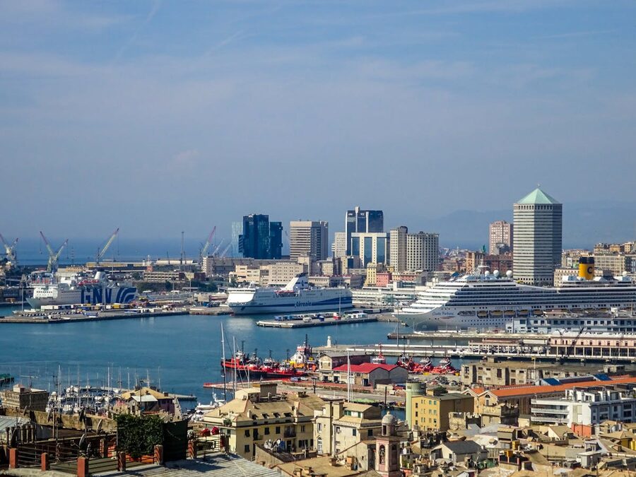 Aerial view of Genoa harbour showing the city skyline and port area under clear blue sky
