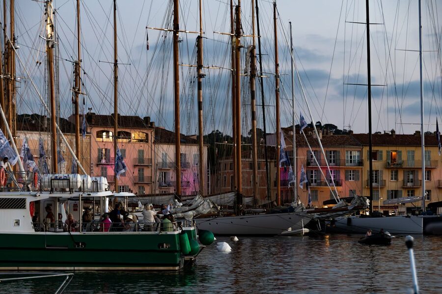 Evening view of boats docked at Saint-Tropez marina with warm light on colourful buildings