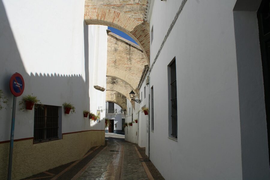 Picturesque narrow street with whitewashed walls and stone arches