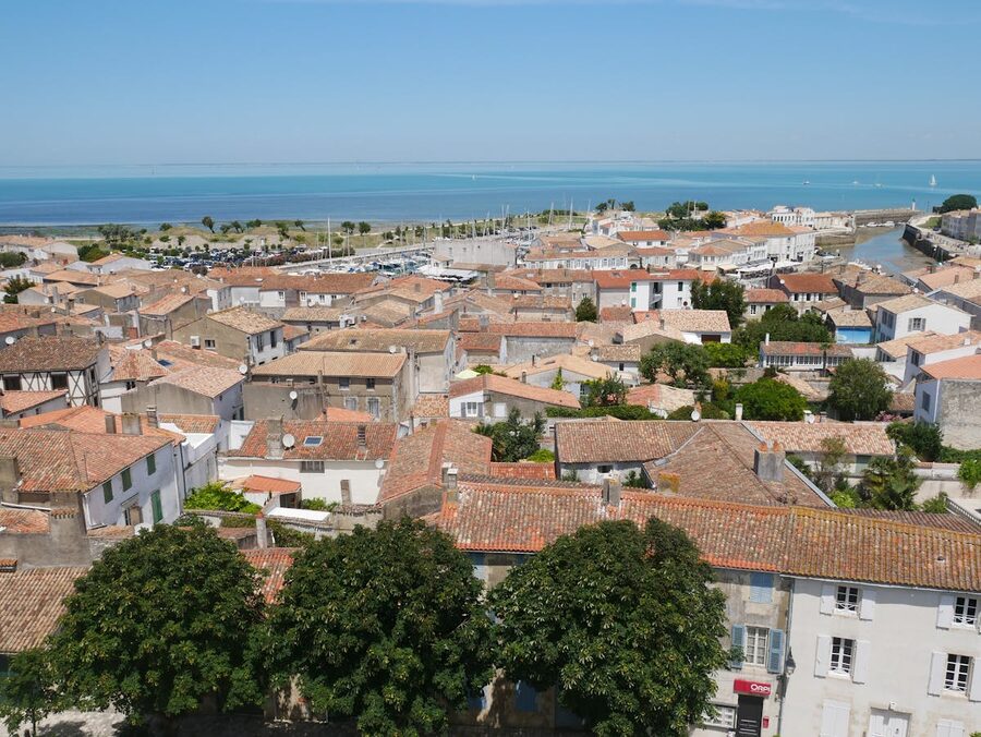 Panoramic aerial view of traditional architecture in Saint-Martin-de-Re with the Ile de Re bridge in the background