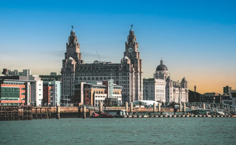 The iconic Royal Liver Building and Liverpool waterfront viewed from across the Mersey at sunset