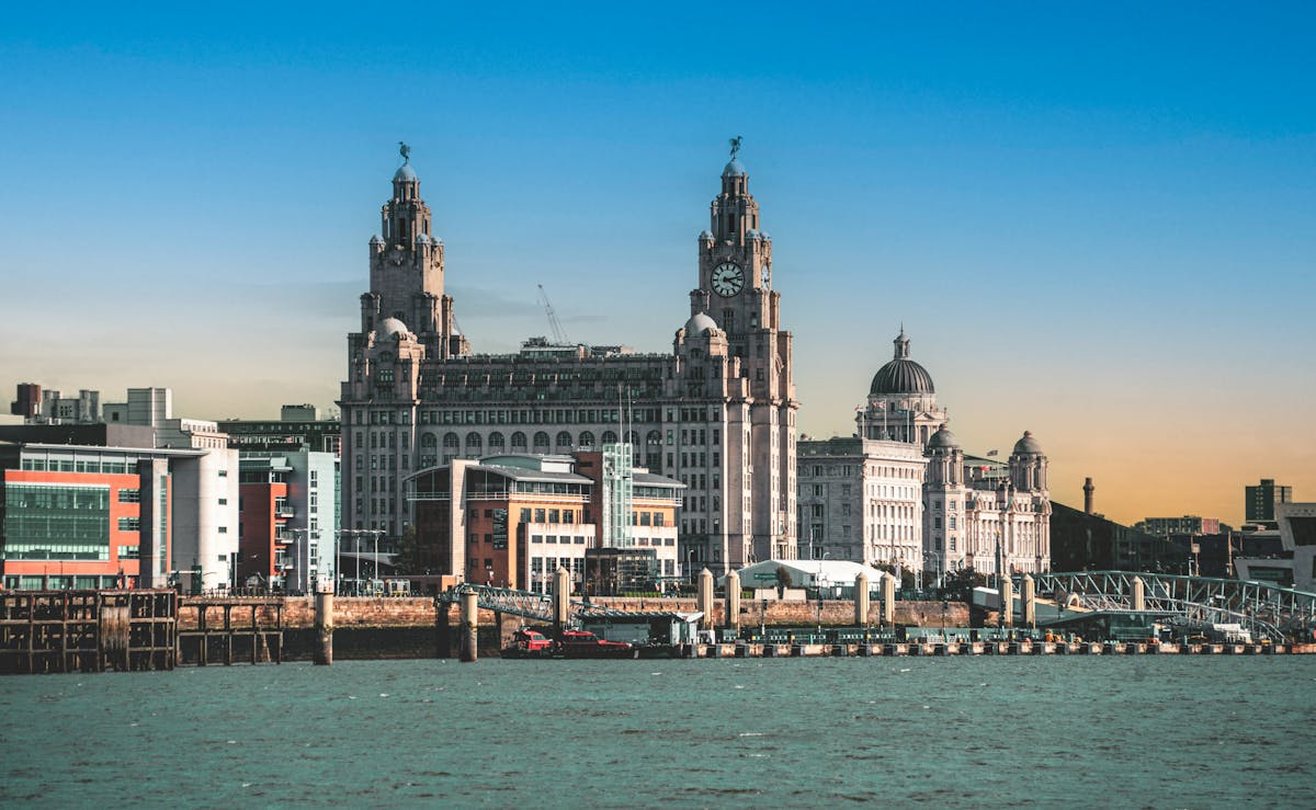The iconic Royal Liver Building and Liverpool waterfront viewed from across the Mersey at sunset