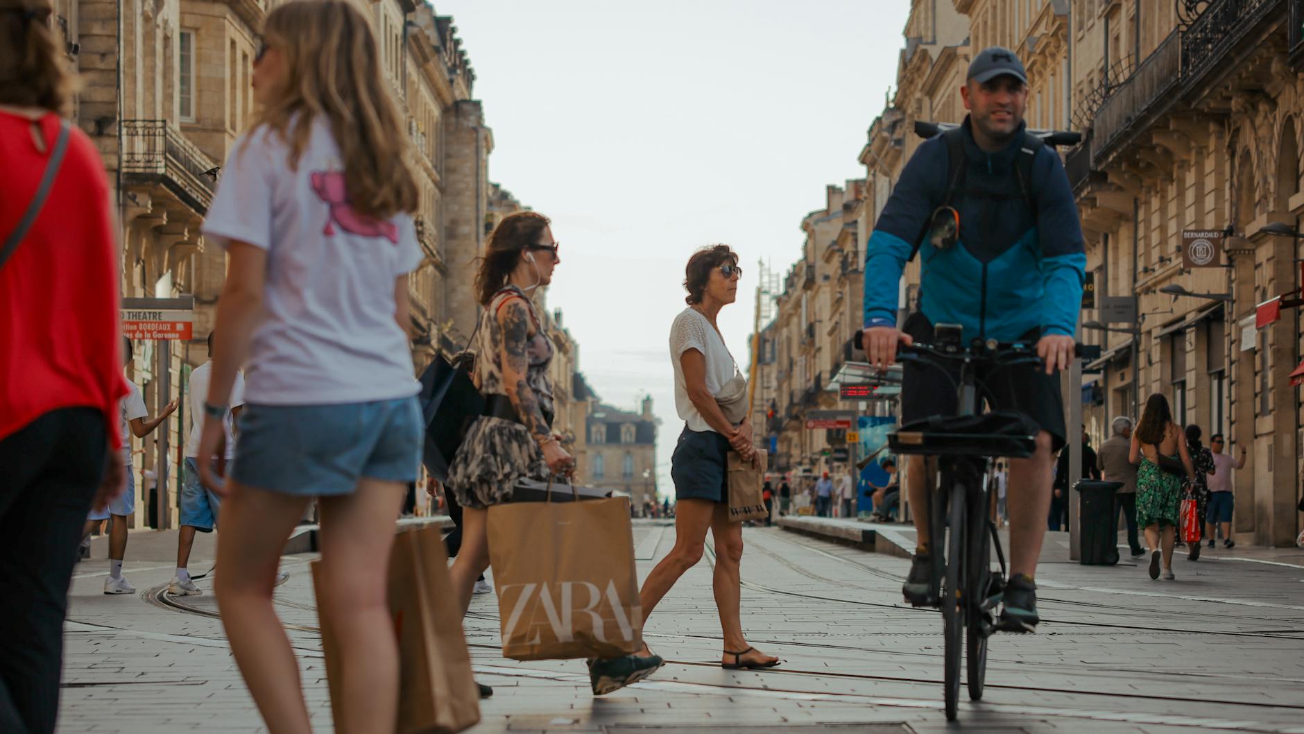 Lively street in Bordeaux France with pedestrians and cyclists amidst historic architecture