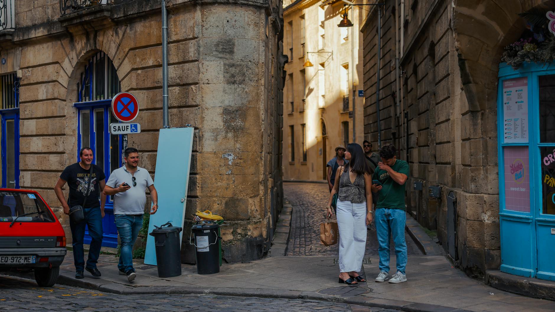 Casual street scene in Bordeaux France with locals walking past historic architecture