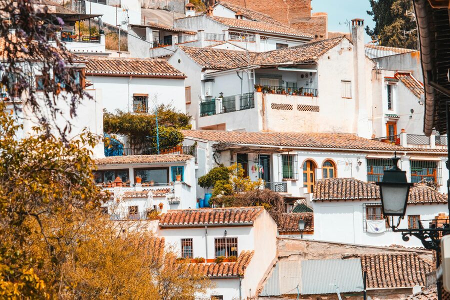 Classic Andalusian whitewashed buildings with balconies and terracotta rooftops in Granada