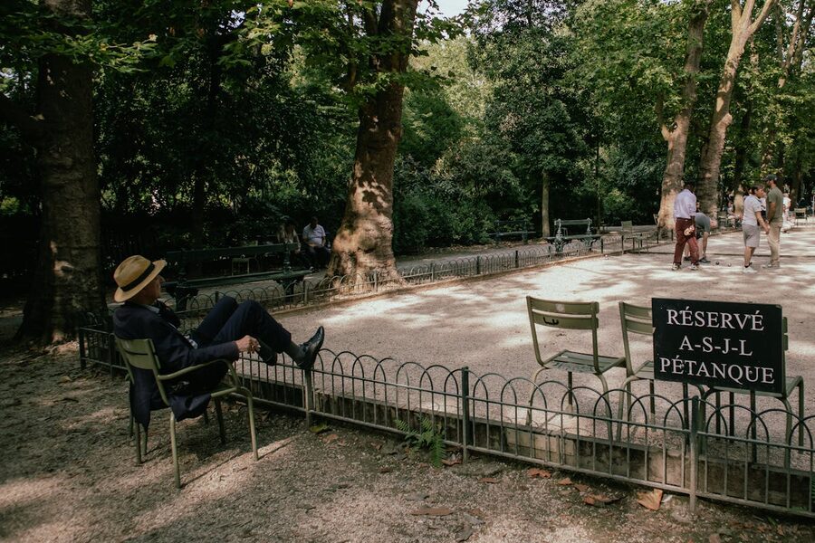 People playing petanque under shady trees in a French park