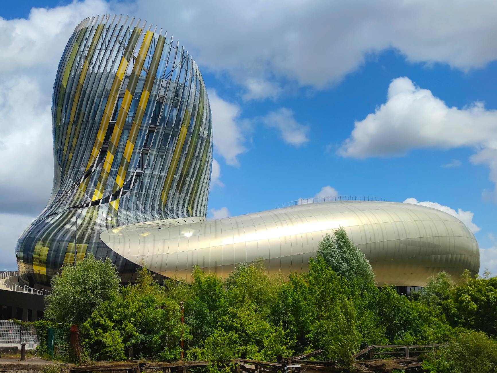 Modern curved architecture of La Cite du Vin wine museum in Bordeaux against a blue sky