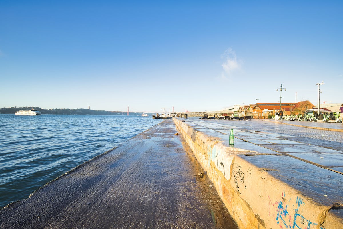 Bright waterfront marina with boats docked in Lisbon, Portugal under clear blue skies