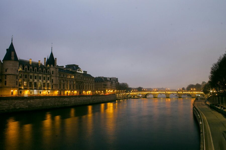 Paris bridges illuminated at night reflecting in the calm Seine River