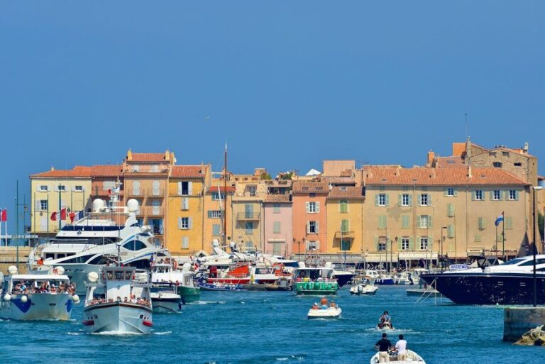 Yachts and traditional boats in Saint-Tropez harbour with pastel buildings along the waterfront