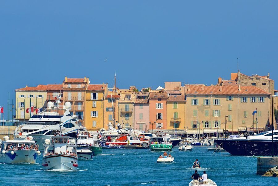 Yachts and traditional boats in Saint-Tropez harbour with pastel buildings along the waterfront