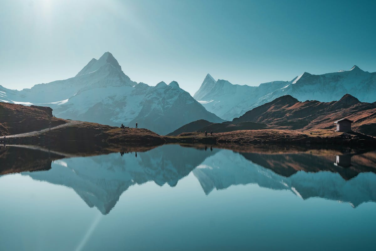 Crystal clear alpine lake Bachalpsee reflecting snow-capped peaks of the Bernese Alps