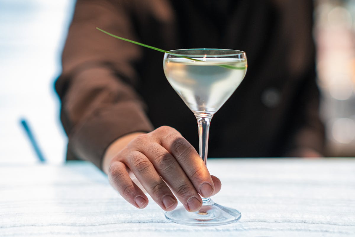 A bartender serves a cocktail in a chic Parisian bar setting