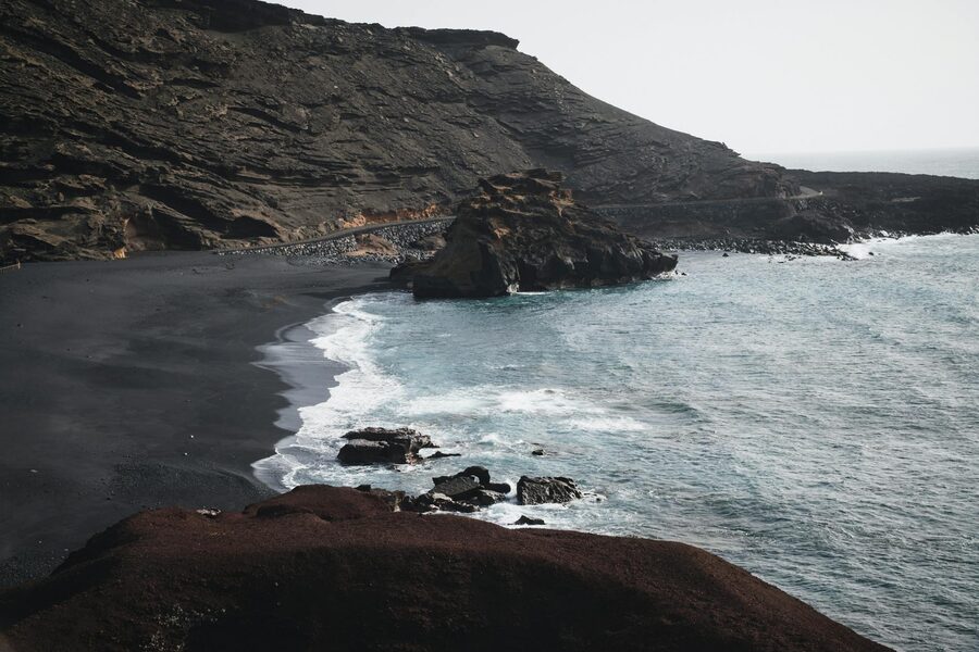 Black sand beach with rugged volcanic coastline in Lanzarote