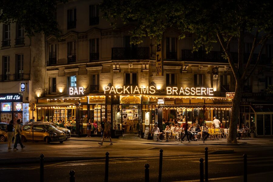 Lively Parisian brasserie with outdoor seating and warm evening light