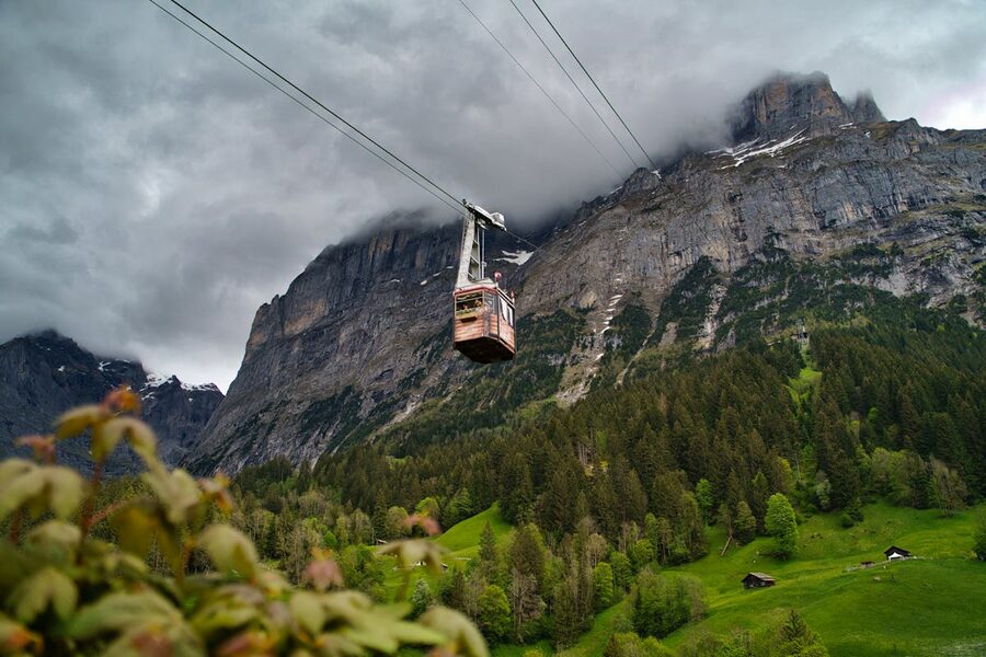 Cable car gondola ascending over Grindelwald village with mountain landscape