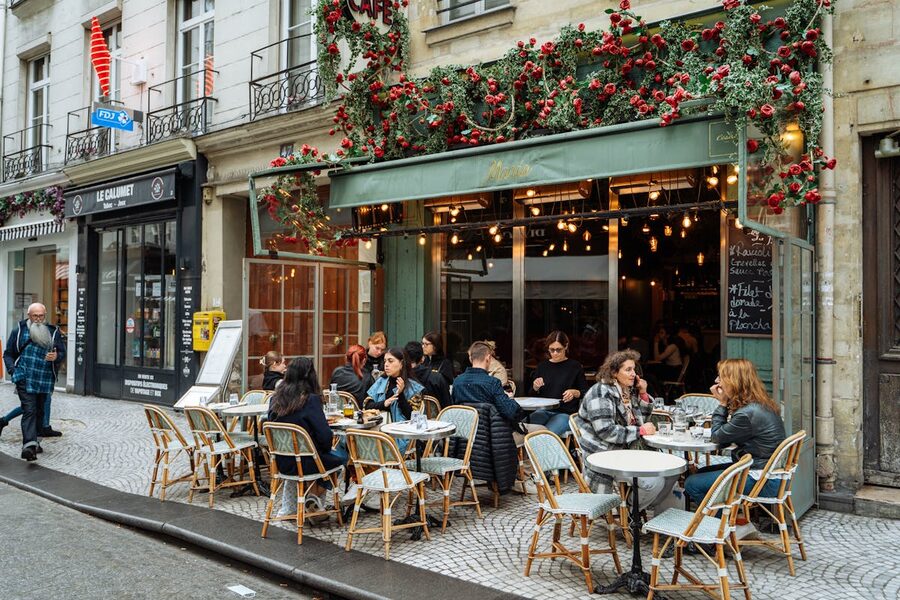 Parisian street cafe with outdoor terrace seating and colourful awnings