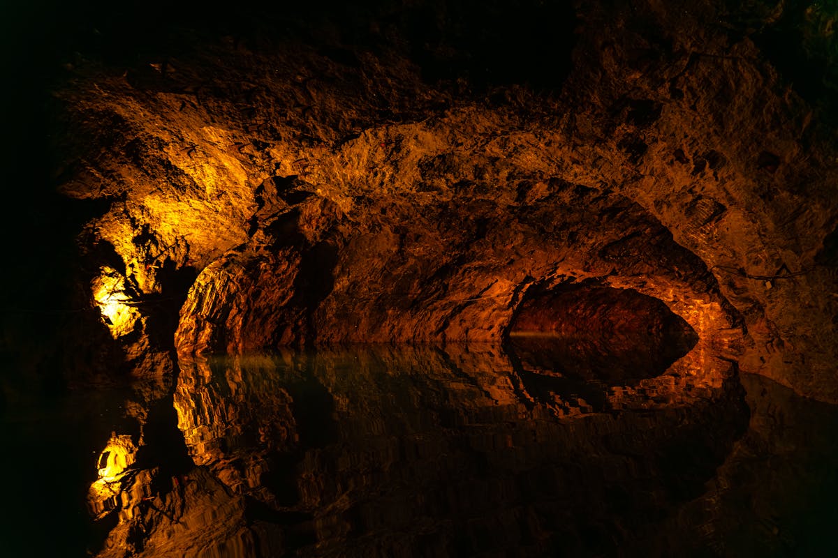 Dimly lit cave in Austria with water reflections on the rocky walls
