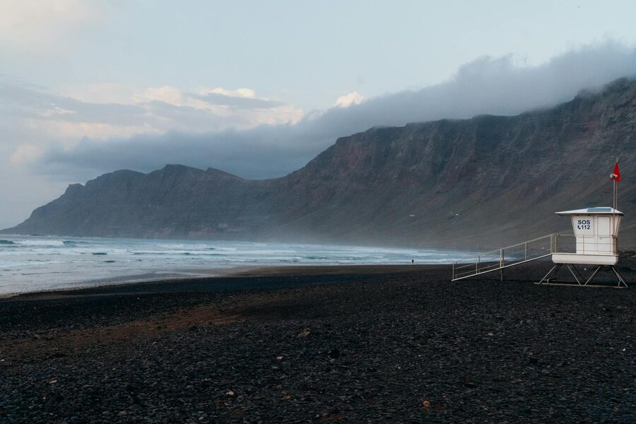 Famara Beach in Lanzarote with towering cliffs in the background and lifeguard tower