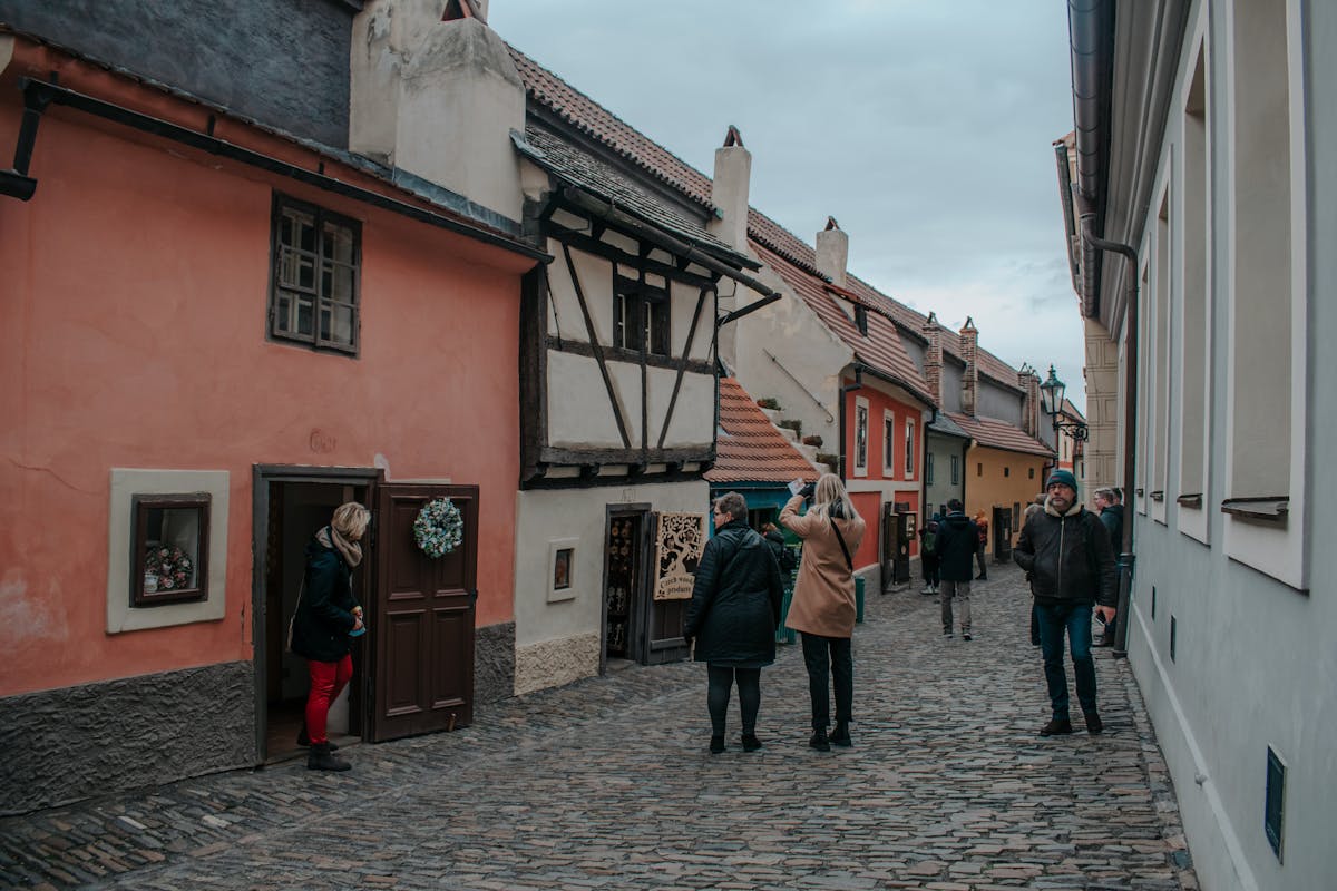 People walking past the colorful small houses on Golden Lane inside Prague Castle