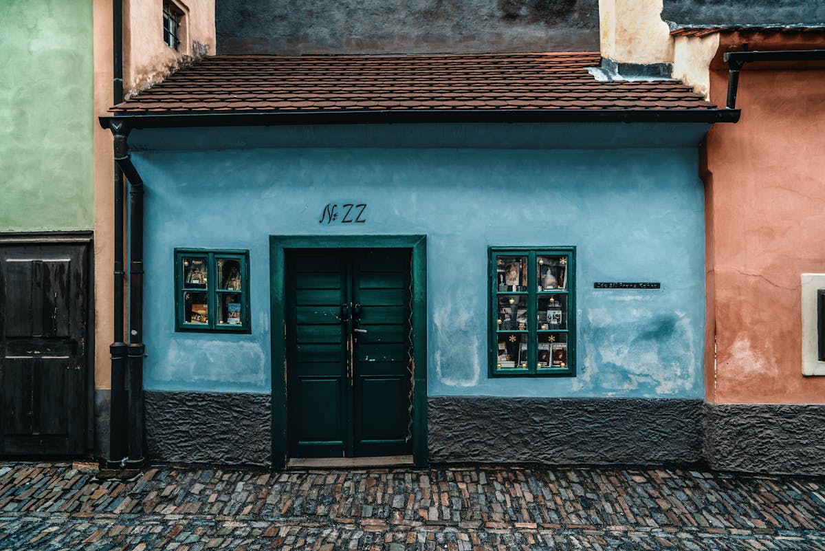 Small medieval house with blue walls and green door on Golden Lane at Prague Castle