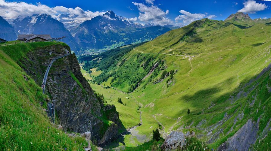 Glass walkway extending from a cliff face at First above Grindelwald with mountain panorama