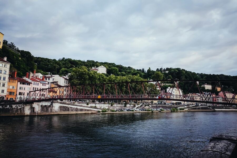 Pedestrian footbridge crossing the Saone River in Lyon with historic buildings