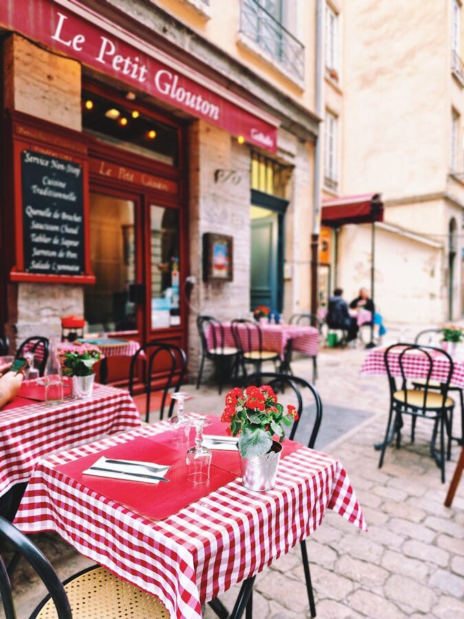 Charming outdoor cafe with checkered tablecloths in a historic Lyon street