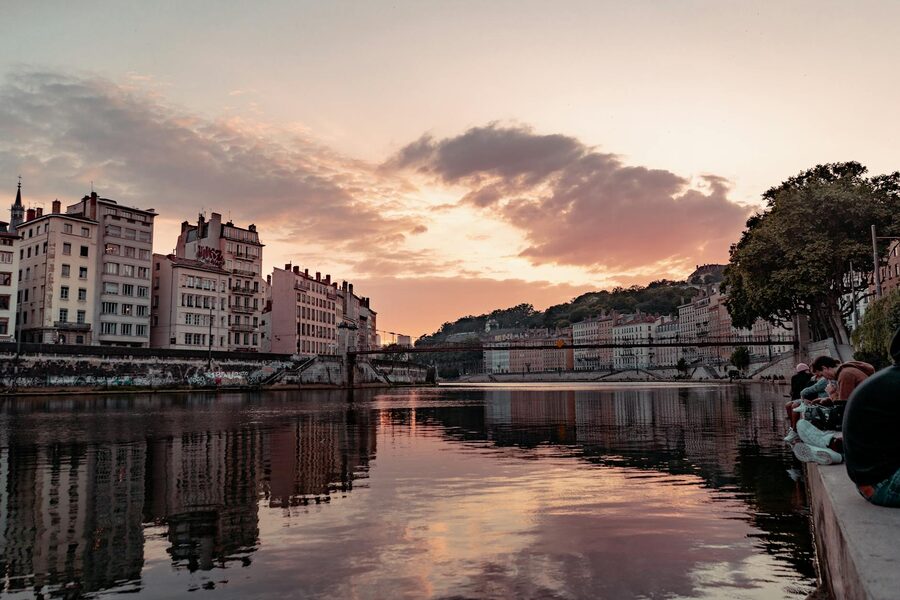 Golden sunset reflecting on the Saone River in Lyon with townhouses along the bank