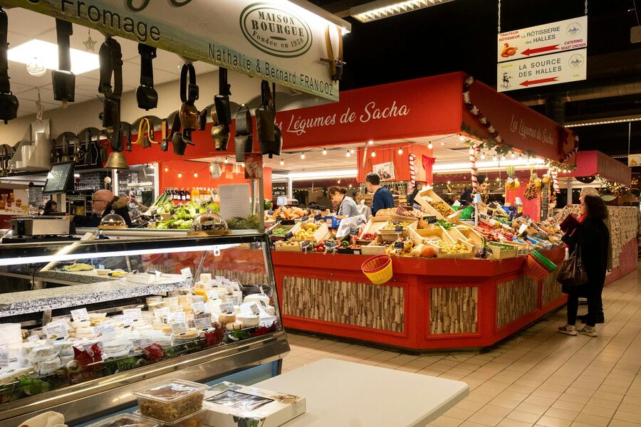 Busy indoor market hall with stalls selling fresh produce and local specialties