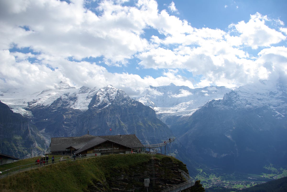 A rustic Swiss mountain lodge with the Alps rising behind it in Grindelwald