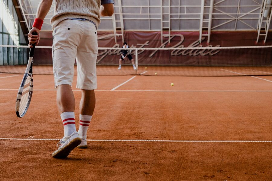 Two tennis players on a red clay court during a match