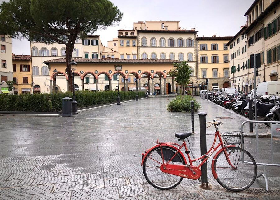 Piazza dei Ciompi in Florence with historic architecture and a locked red bicycle