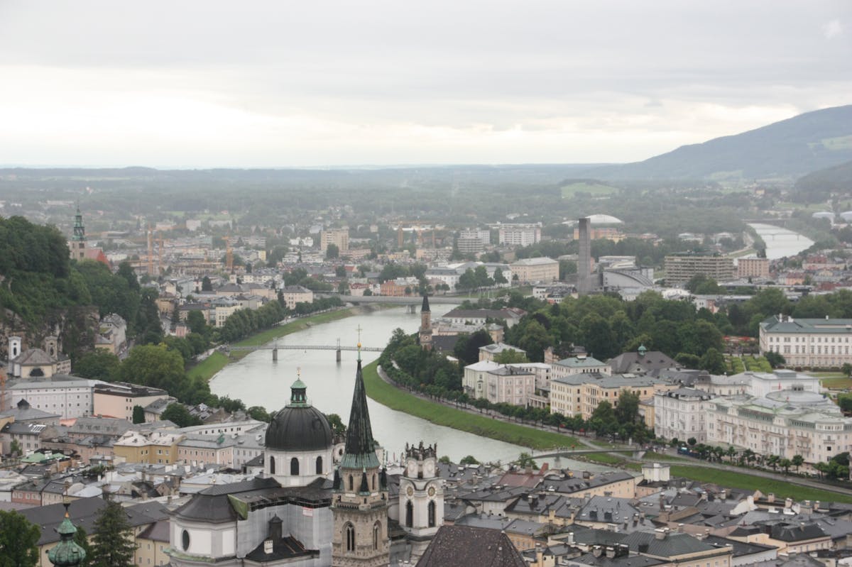 Aerial view of Salzburg city showing churches the Salzach River and surrounding mountains
