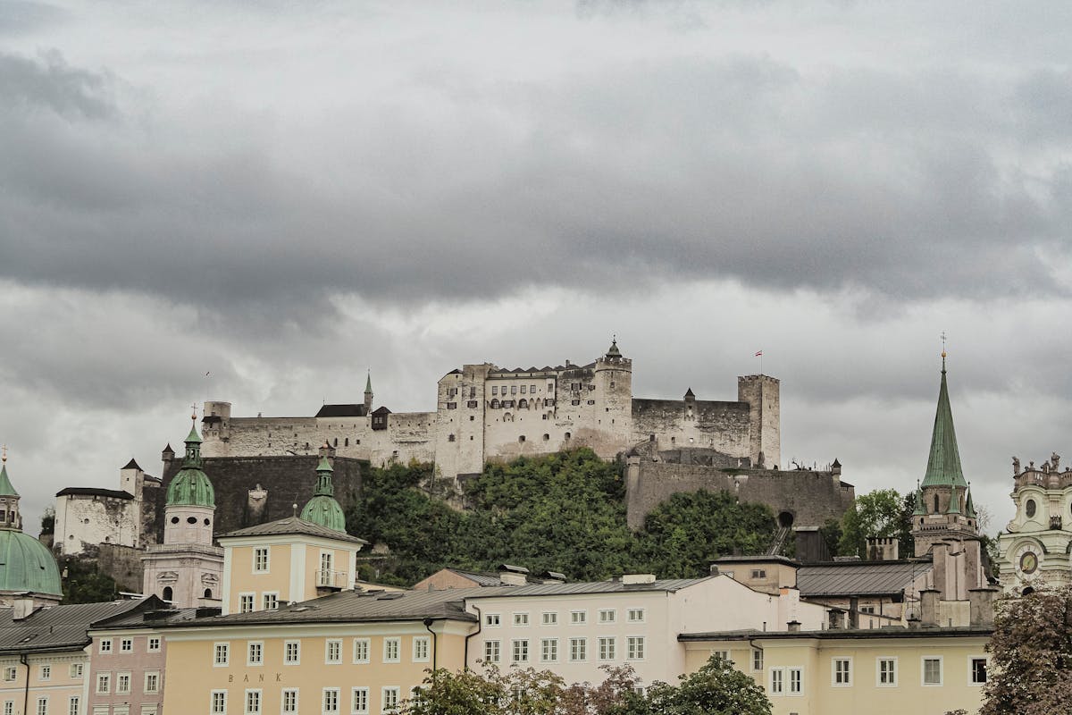 Row of colorful historic buildings in Salzburg with Hohensalzburg Fortress on the hill behind